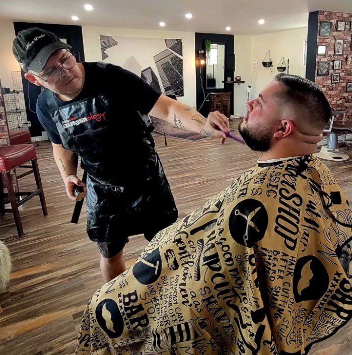 Jeffrey Dugas working as a barber
