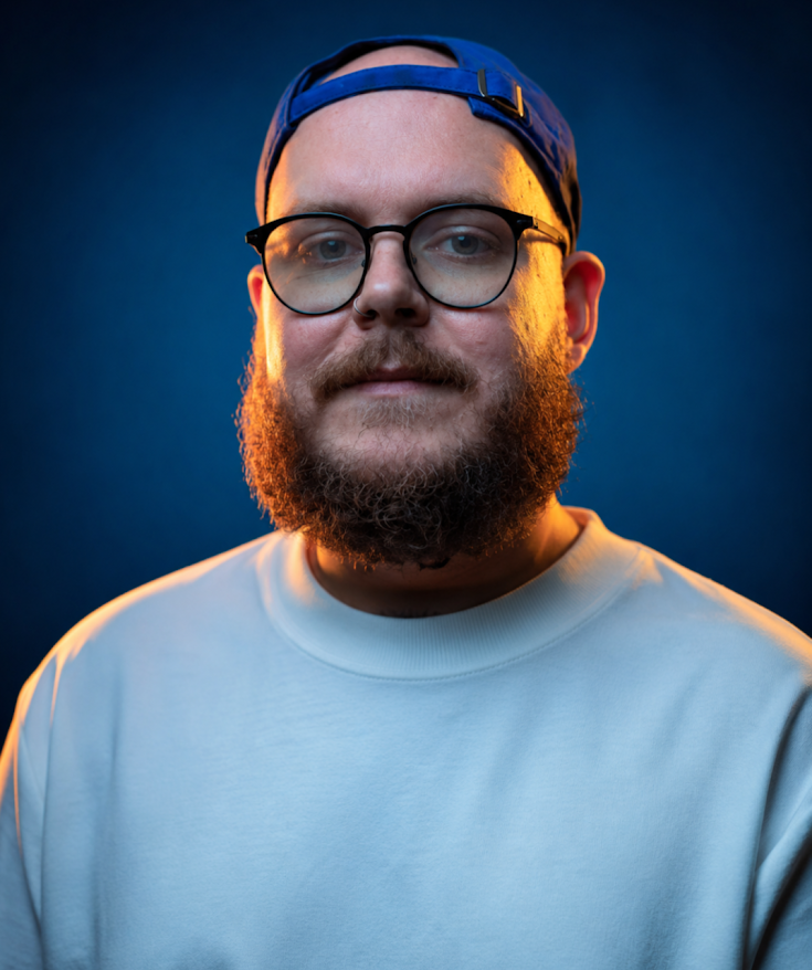 Jeffrey Dugas wearing glasses and a blue cap