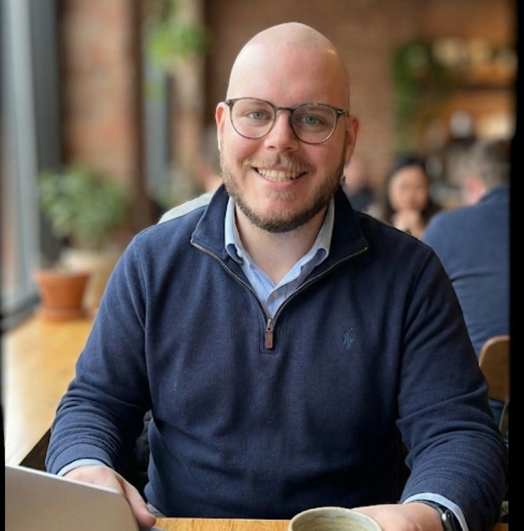 Jeffrey Dugas sitting at a table with a laptop